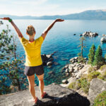 woman standing on a rock looking out over lake tahoe